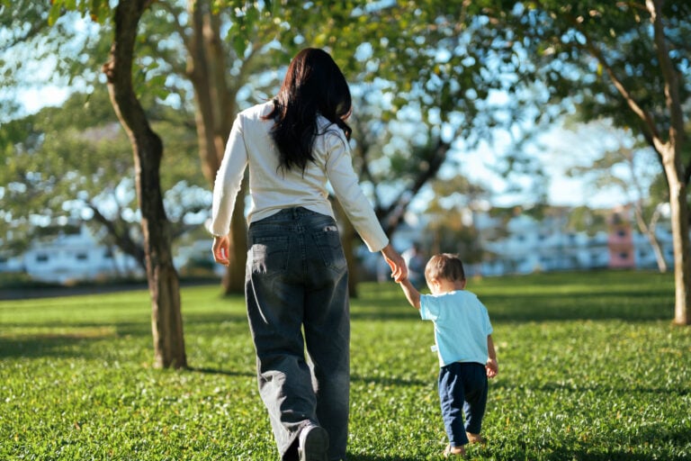 Mother and son holding hands in park